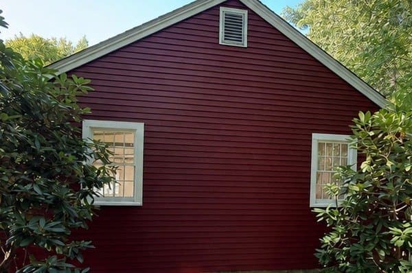 The same clapboard siding after a full repaint, deep and even in colour