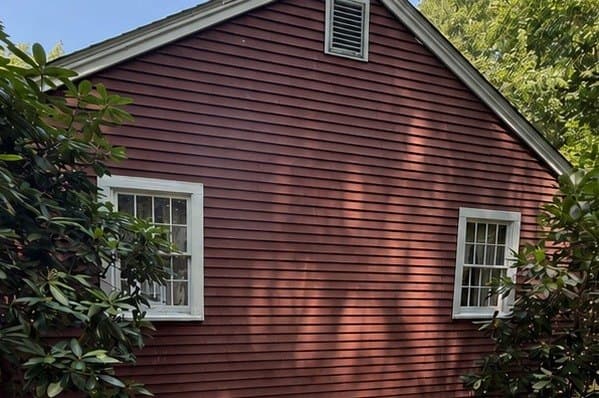 Weathered, sun faded red clapboard siding before repainting