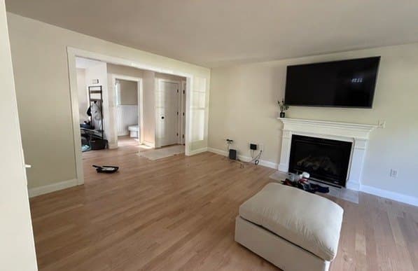 Living room repainted off white around a white fireplace mantel